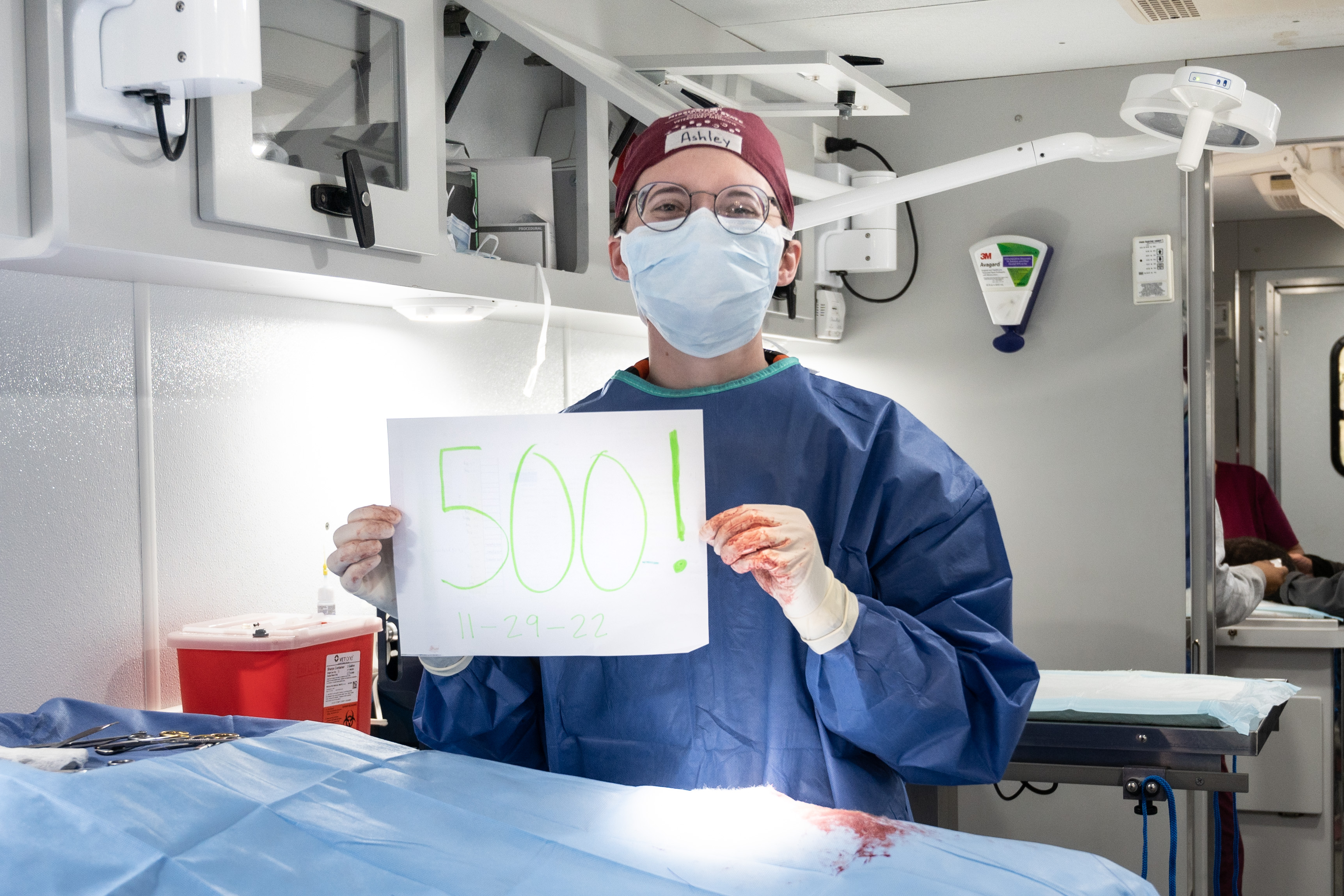Student Ashley Smith holds a sign commemorating her 500th surgery