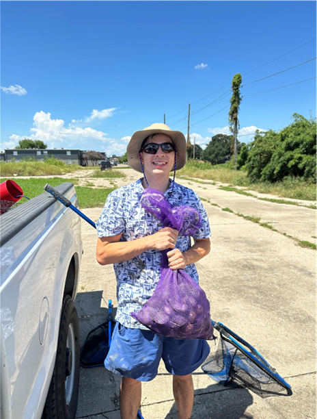 Jonah Nguyen holds a bag of collected apple snails.