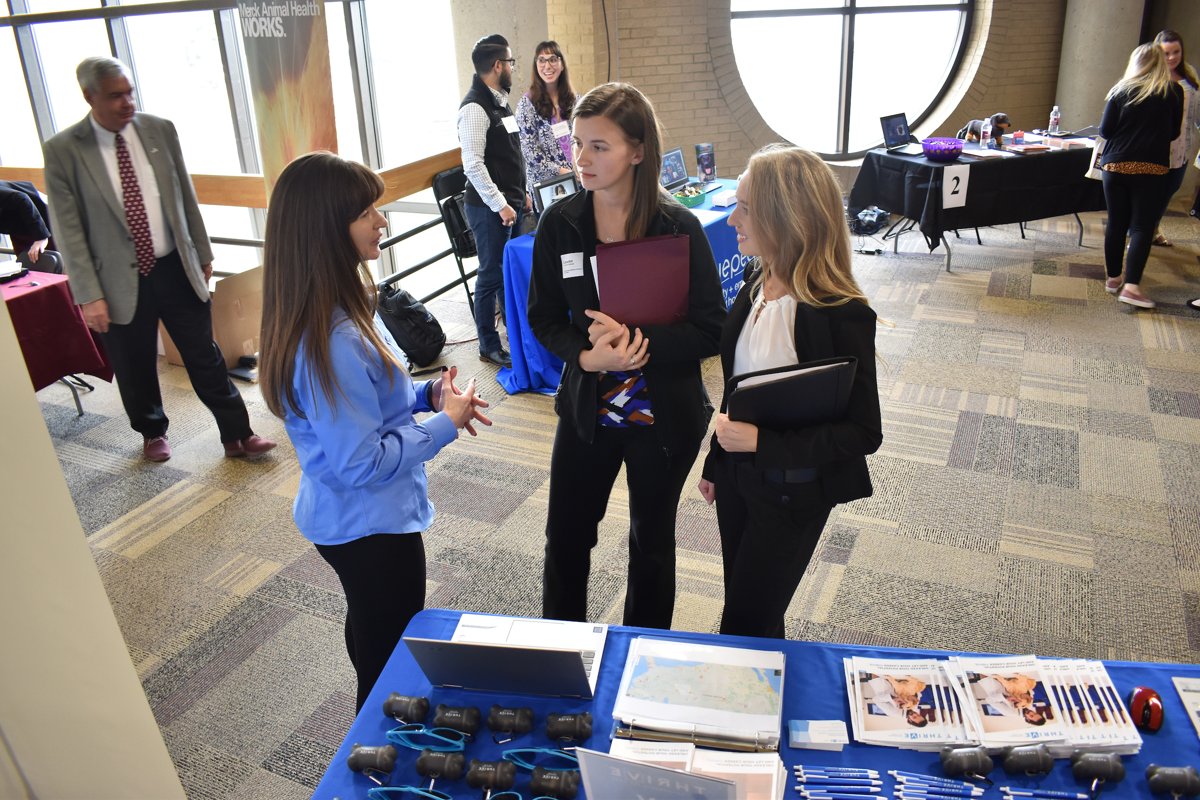 Students engage with a potential employer at a career fair