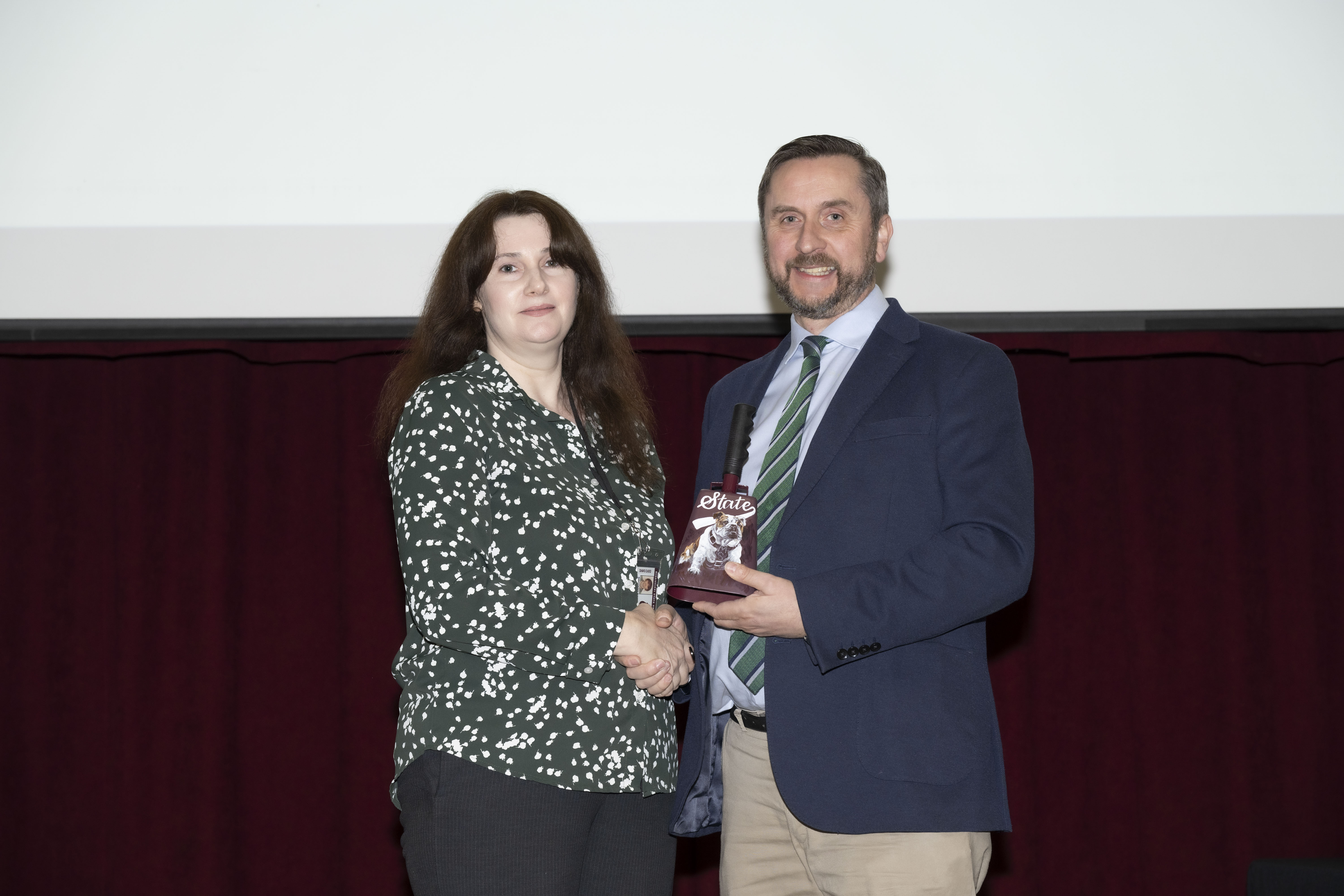Dr. Brittany Baughman receives the Pegasus Award for Service from Philip Robinson, head of the Department of Pathobiology and Population Medicine.