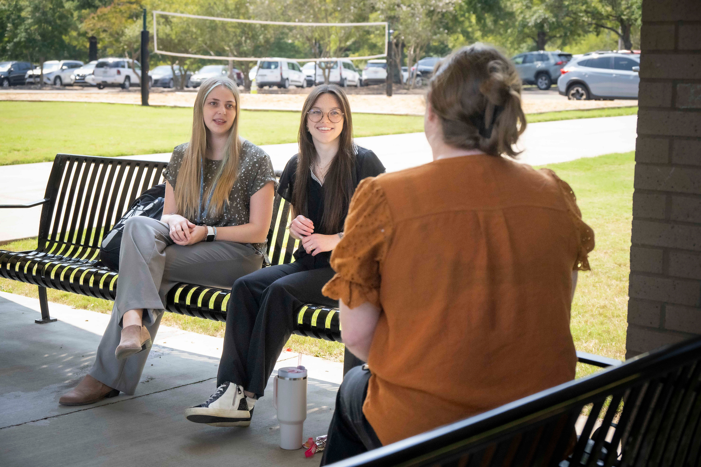 Three students chatting outside.