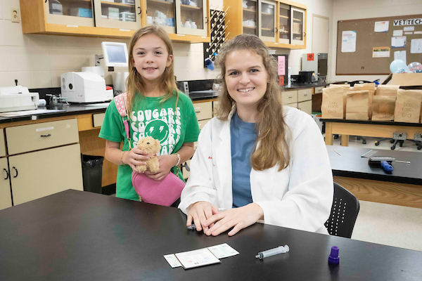 A kid and a vet student at open house.