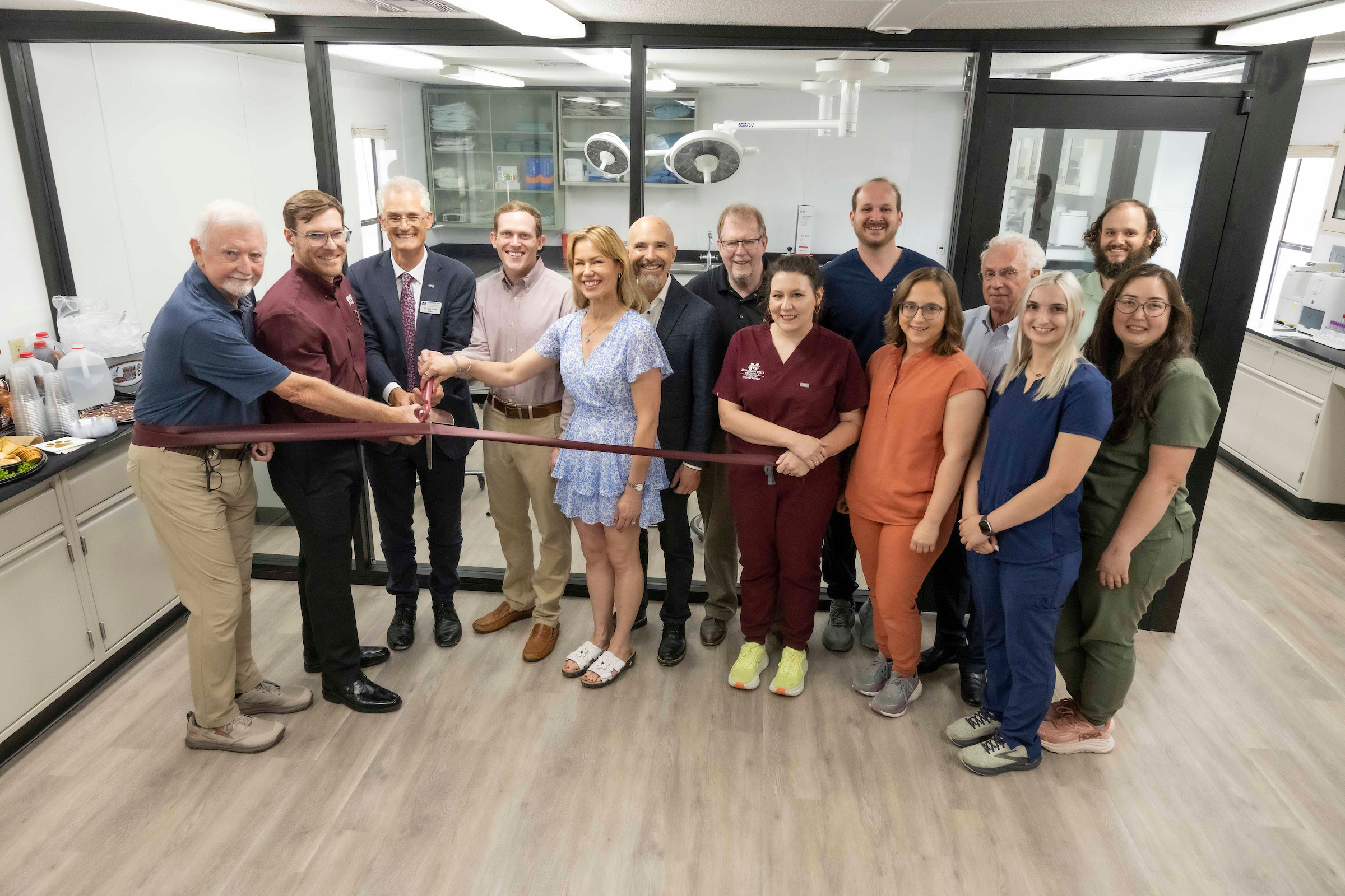 14 people cutting a ribbon