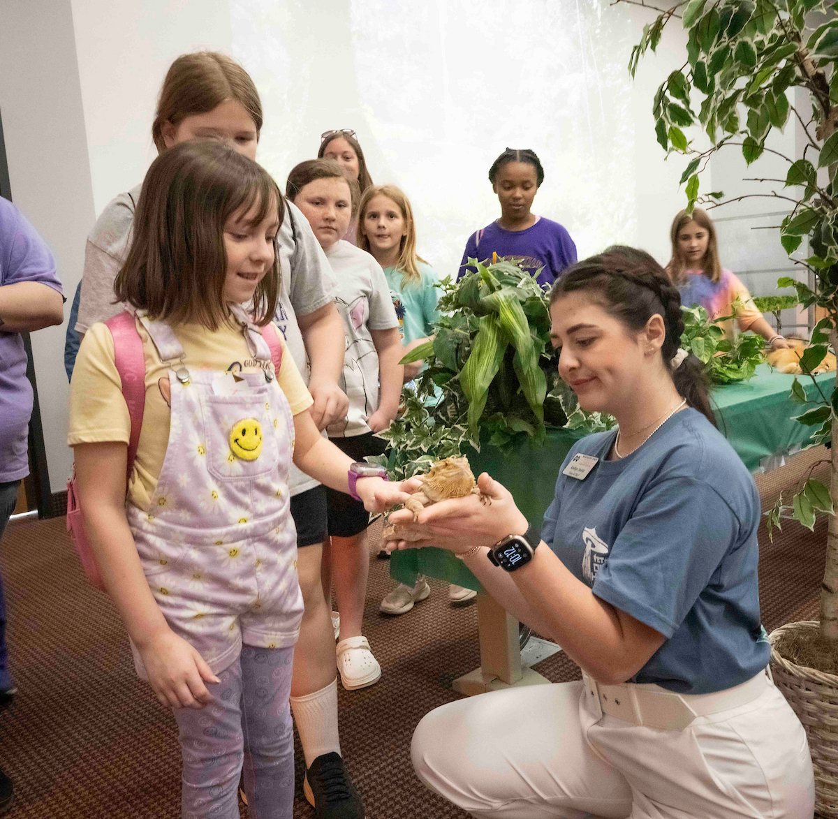 A CVM student shows children a lizard.