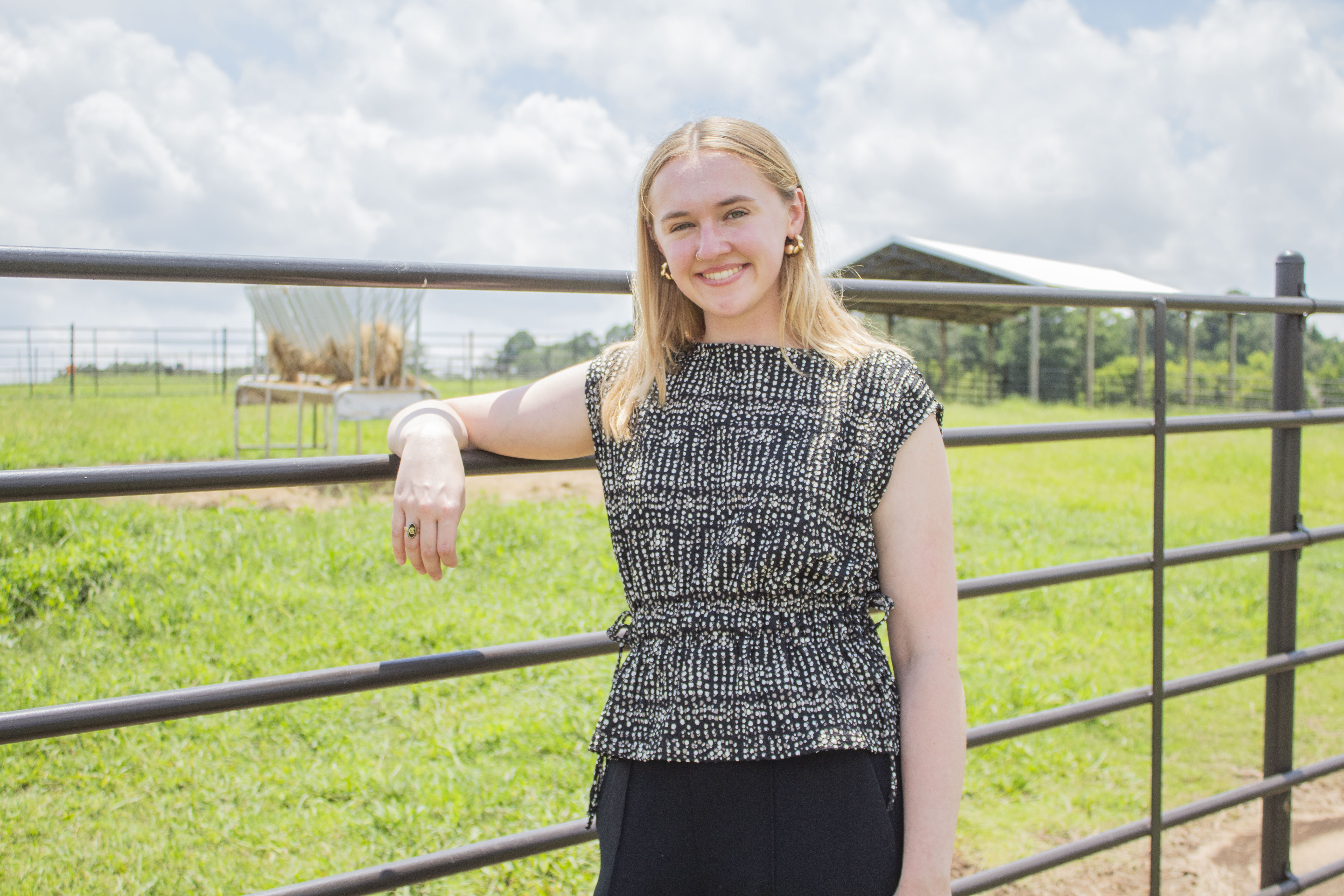 Second-year Mississippi State University College of Veterinary Medicine student Christianna Hoshko stands alongside a metal livestock fence at the college's Starkville campus.
