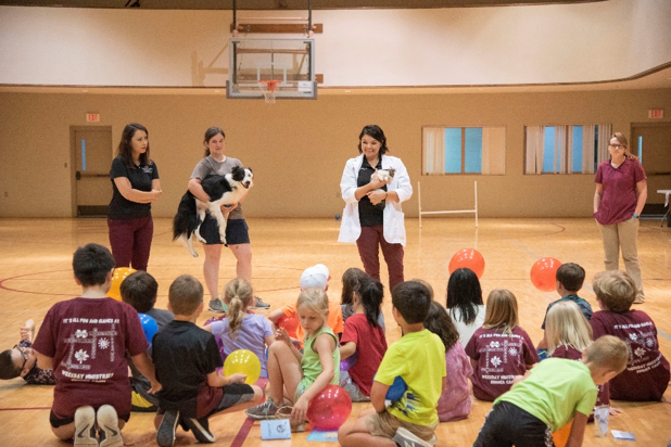 Students gather in a gym to learn about animals